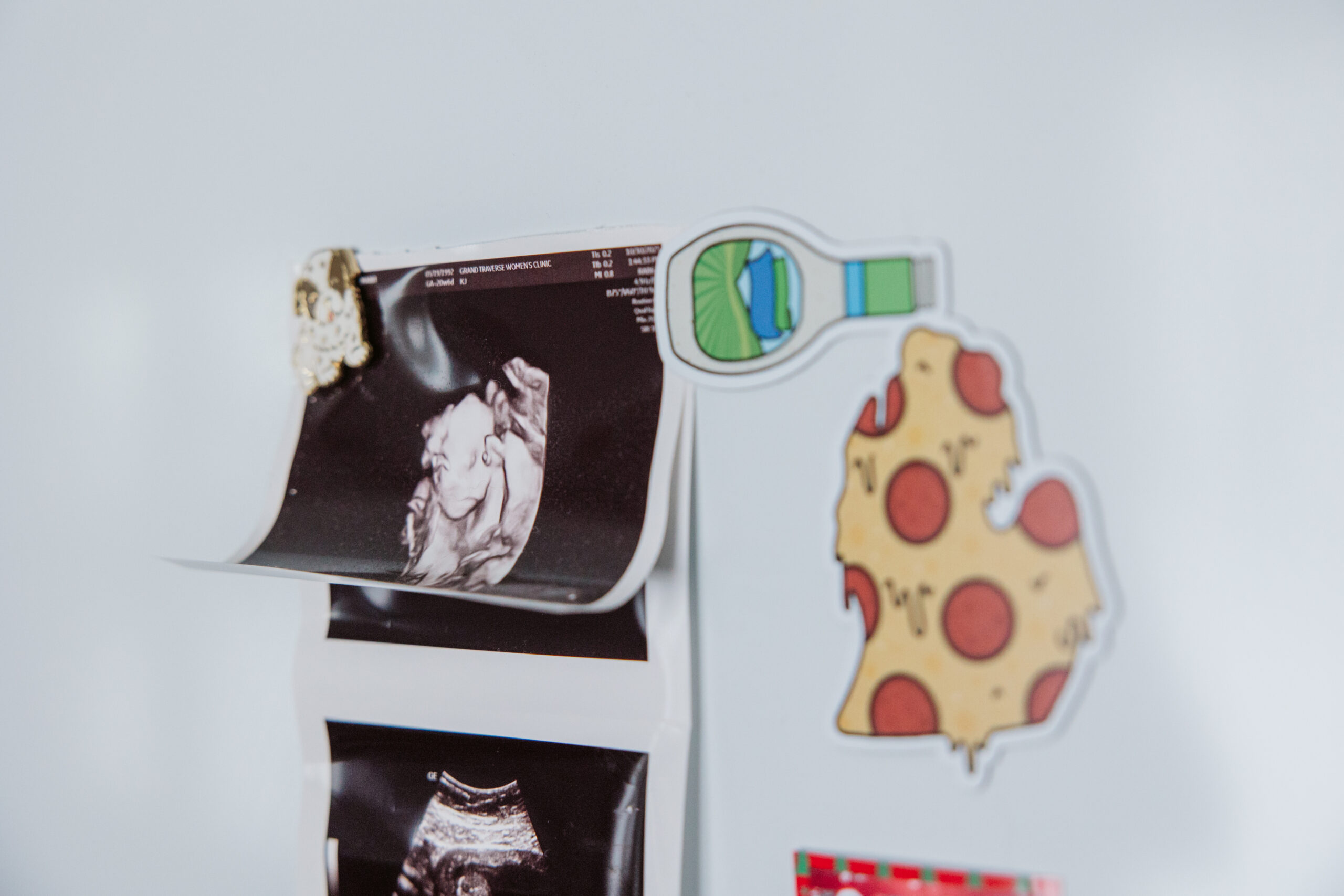ultrasound hanging on fridge durning home maternity photos in traverse city michigan
