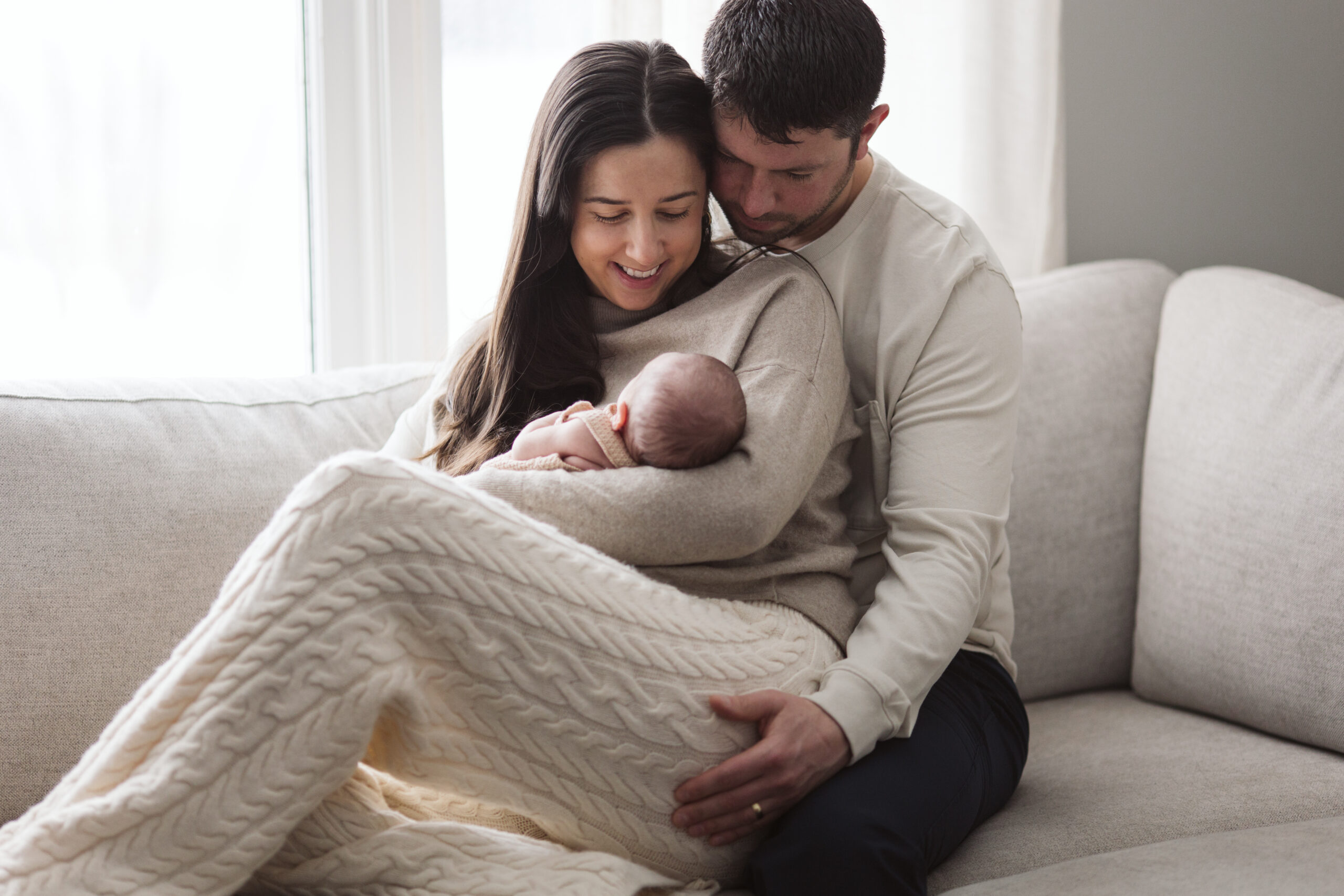 Traverse-city-michigan-photographer husband and wife holding baby during newborn family photos in traverse city