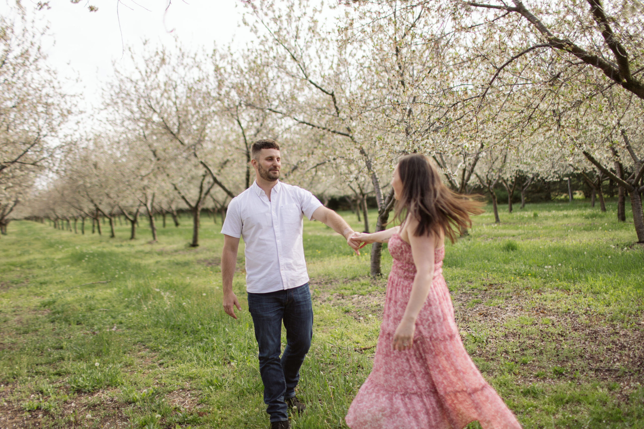 man and woman dancing during blossoms in empire michigan engagement session