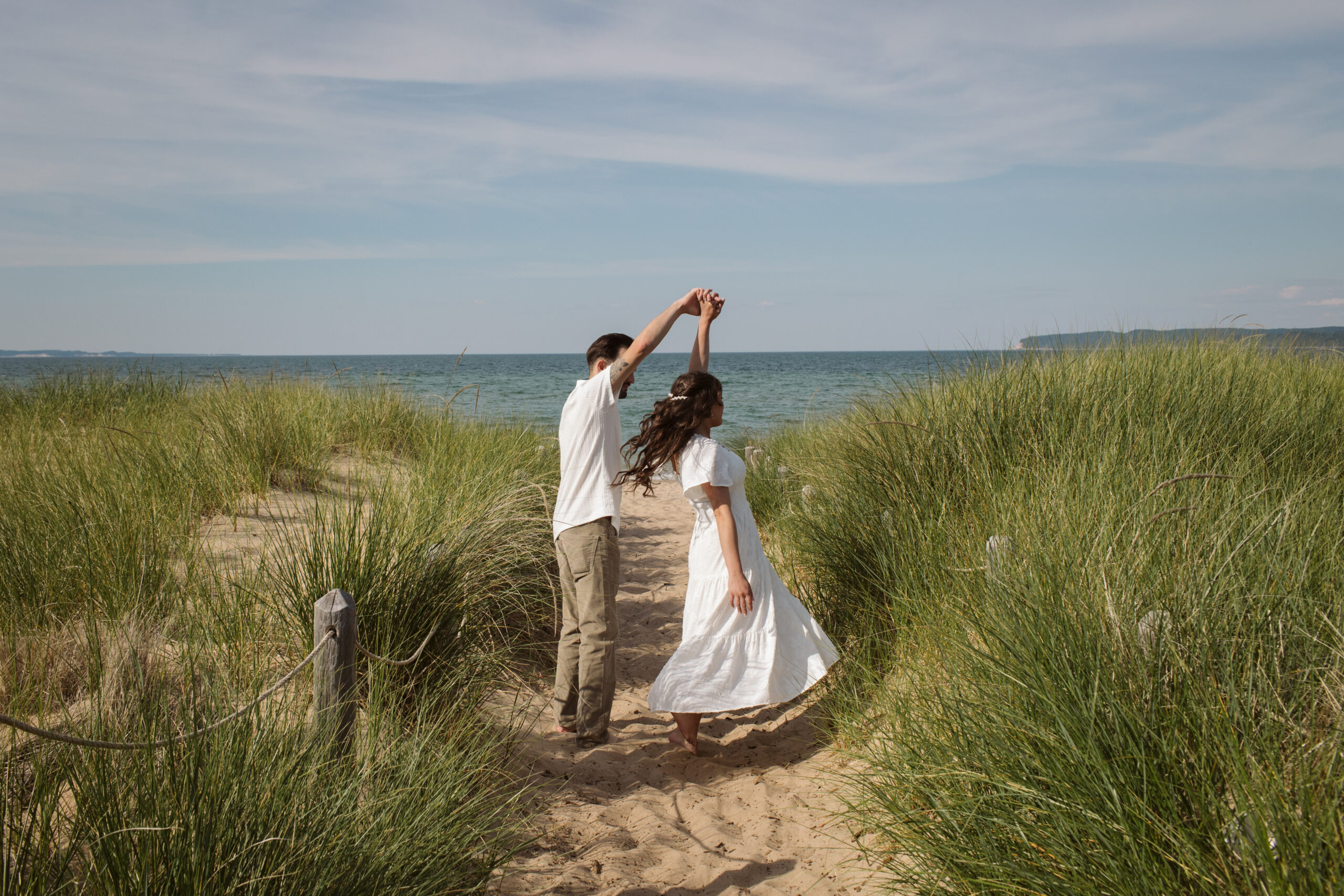 bride and groom dancing on glen haven beach in glen arbor michigan during engagement photos