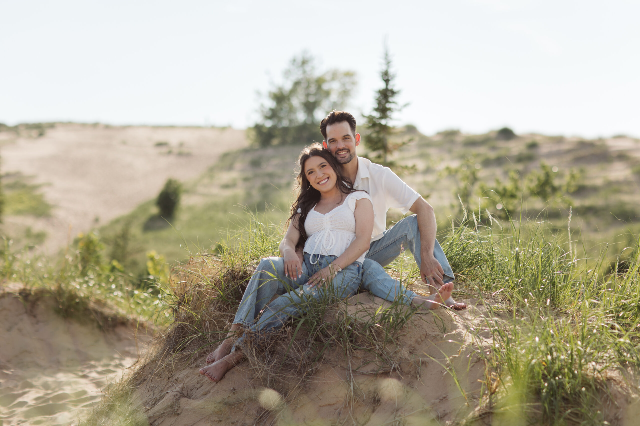man and woman on glen haven beach in glen arbor michigan during engagement photos