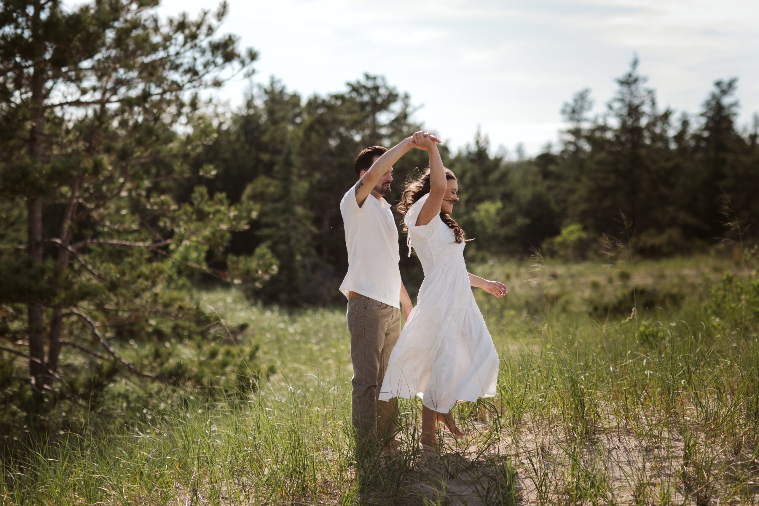 man and woman on glen haven beach in glen arbor michigan during engagement photos
