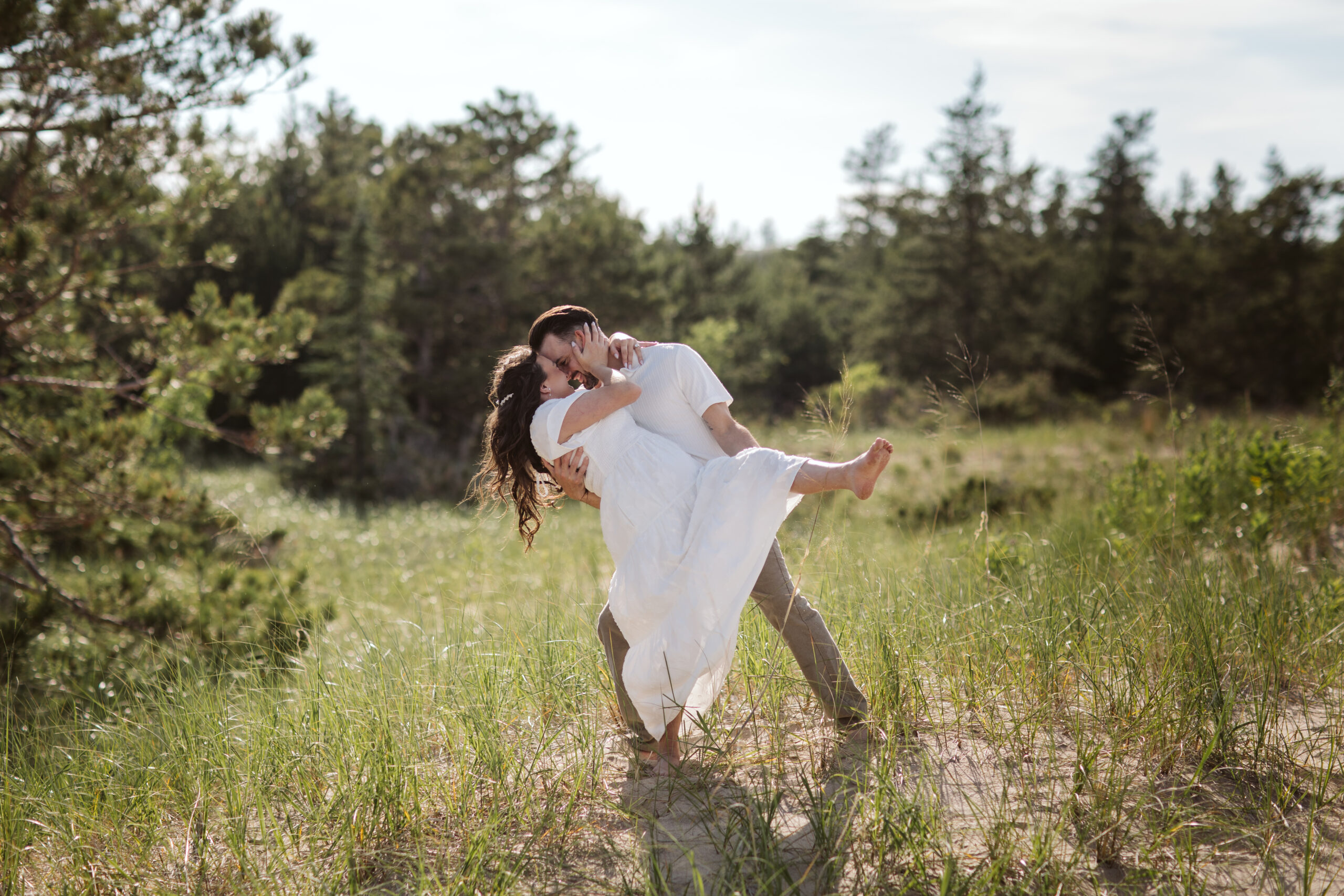 man and woman on glen haven beach in glen arbor michigan during engagement photos