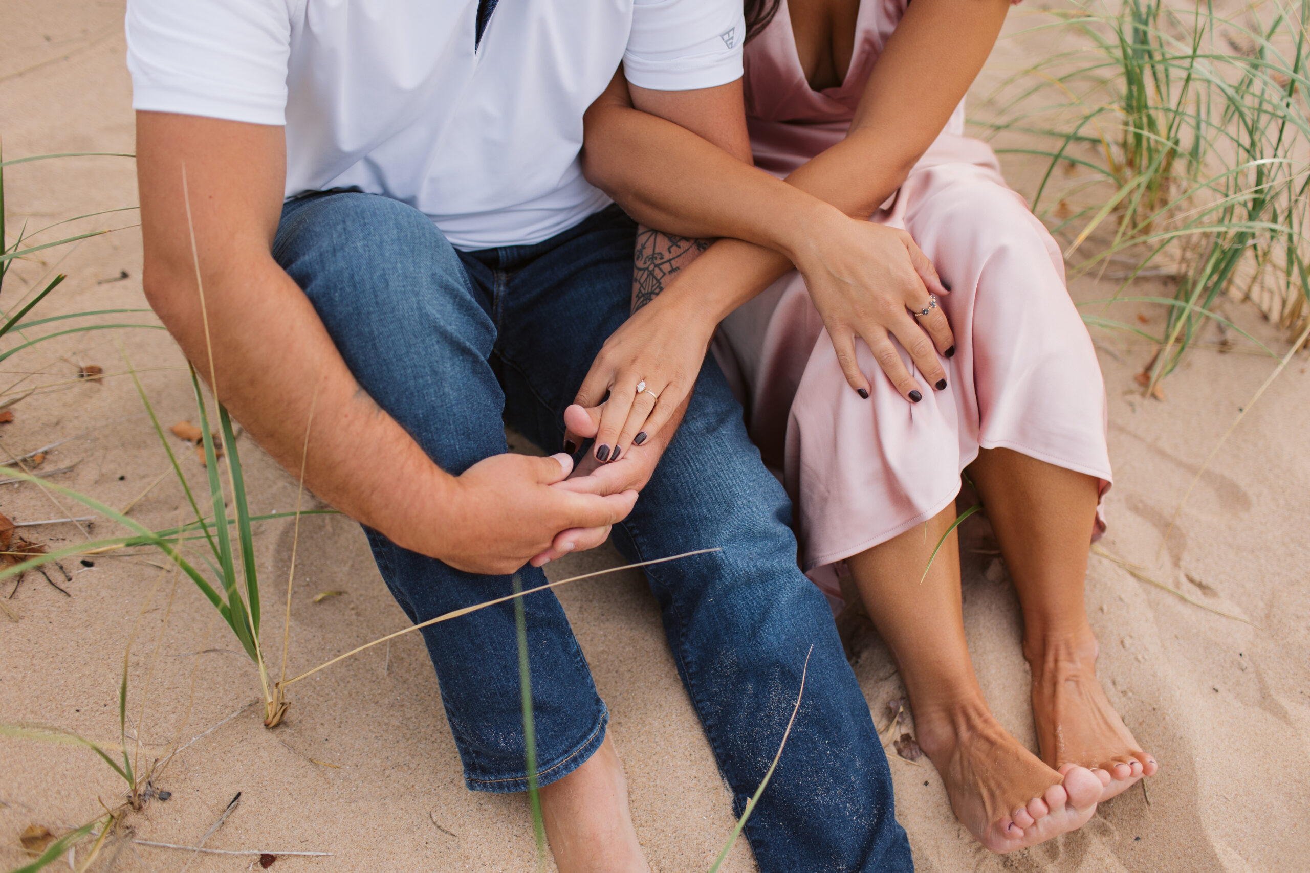 elk-rapids-wedding-photographer bride and groom walking on elk rapids beach in michigan during engagement photos wedding photographer