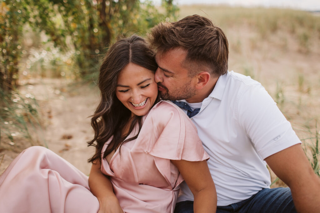 bride and groom on elk rapids beach in michigan during engagement photos wedding photographer