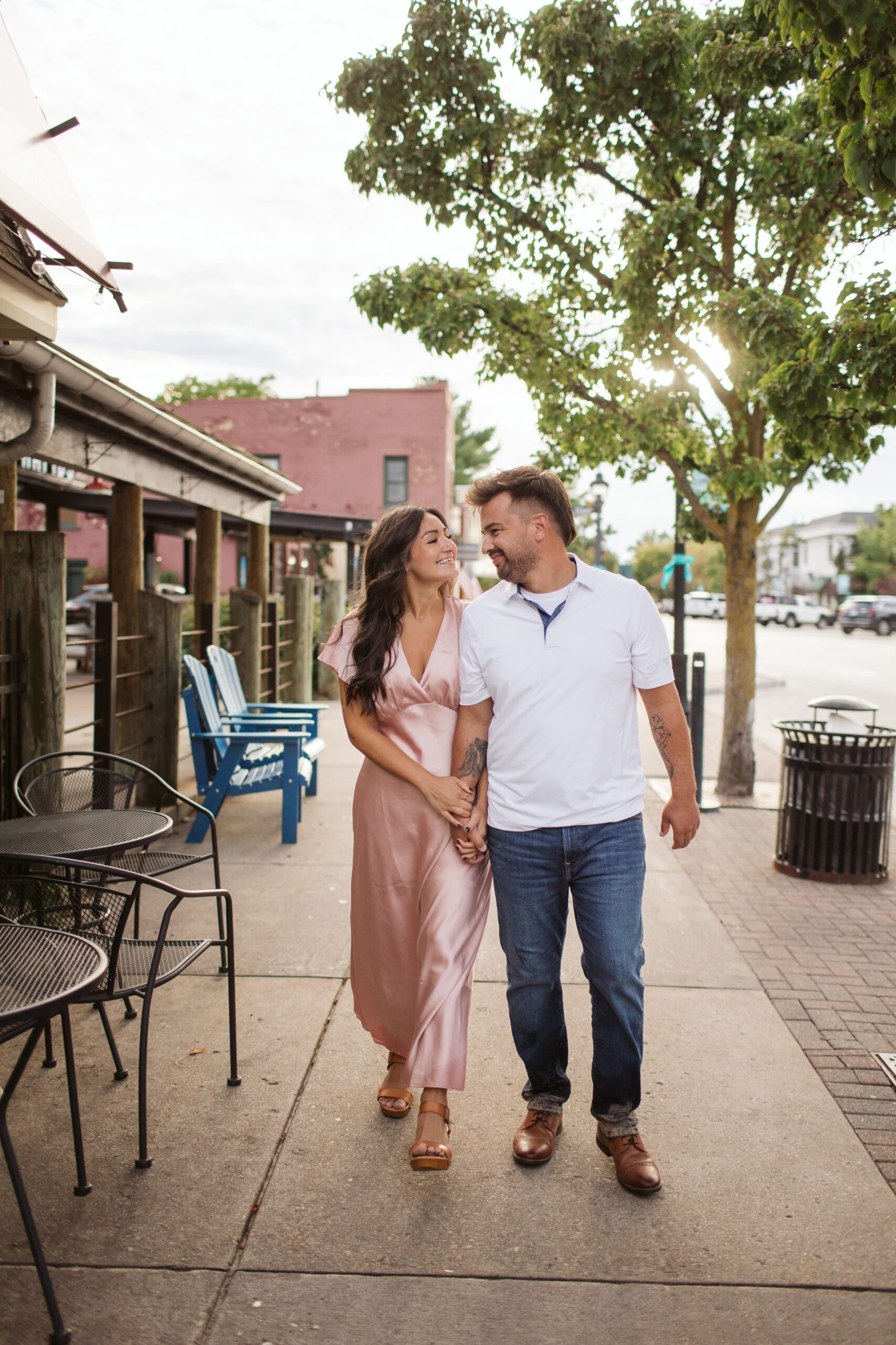 elk-rapids-wedding-photographer bride and groom walking downtown elk rapids michigan during engagement photos wedding photographer